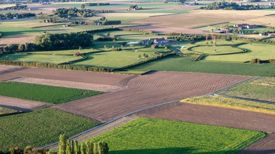 Luchtfoto van velden en een boerderij met een grote tuin