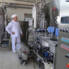 Persoon in witte kledij inspecteert apparatuur van de Food Pilot