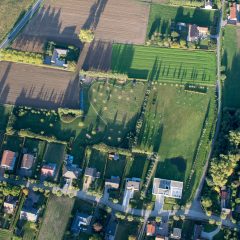 Luchtfoto van een Vlaamse lintbebouwing met huizen en erachter tuinen die het achterliggende landschap afsnijden en afboorden