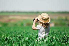 kid with hat on in summer wheat field