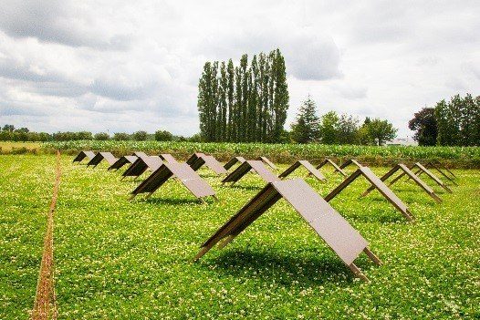 houten afdakjes in tentvorm op een gras-klaver veld