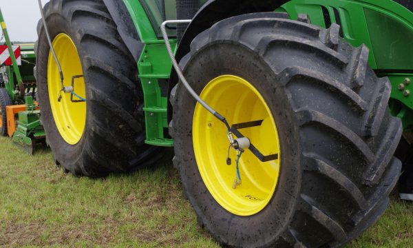 Tractor met grote tractorbanden op een grasakker