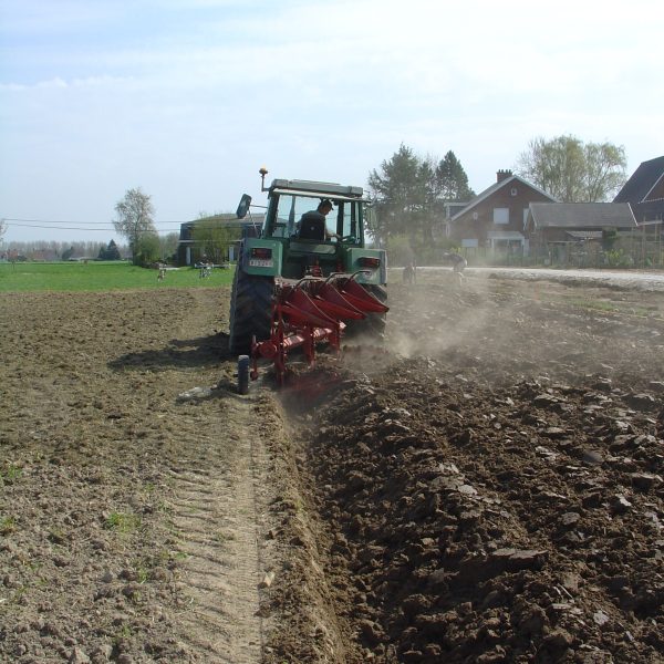 Tractor applying mowed grass to a field