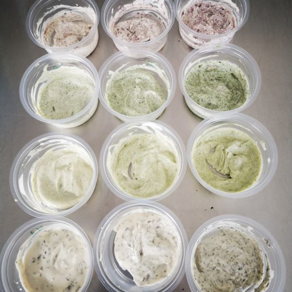 Small pots of white, light green and pink veganaise