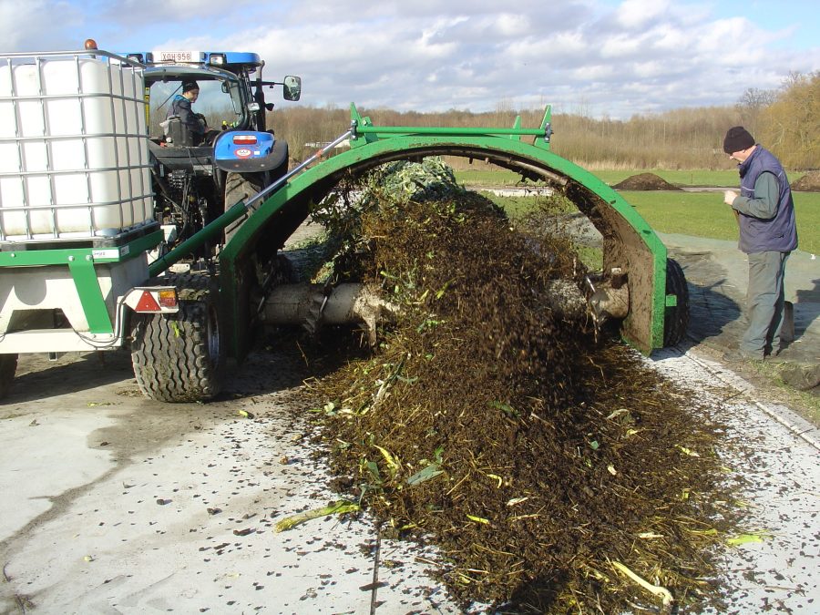 composthoop met compostkeerder en tractor met watertank