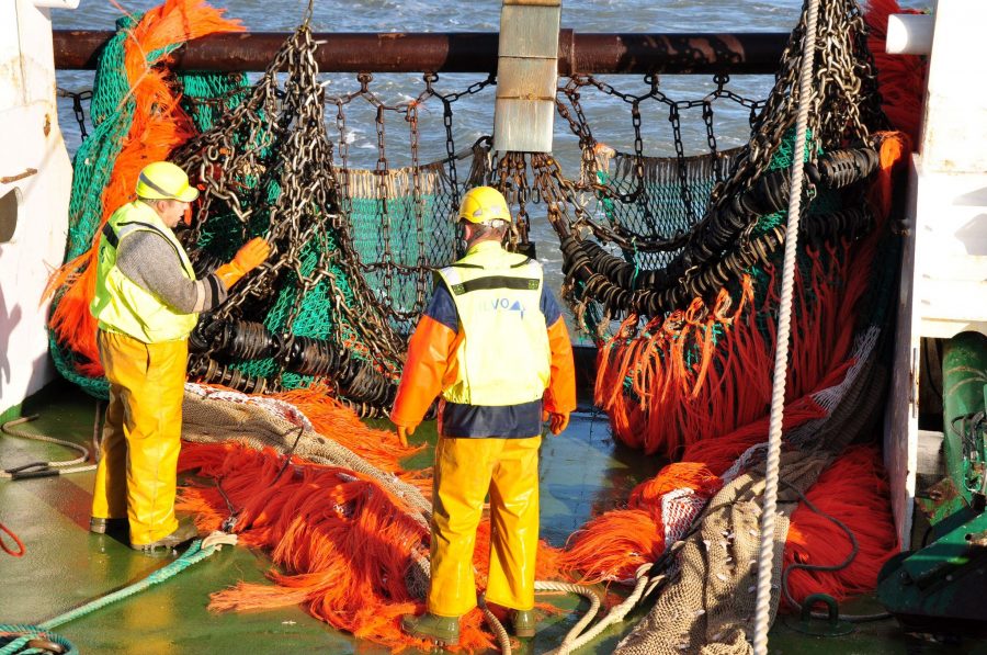 Vissers halen een net binnen op een vissersboot