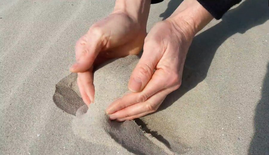 2 handen die zand opscheppen